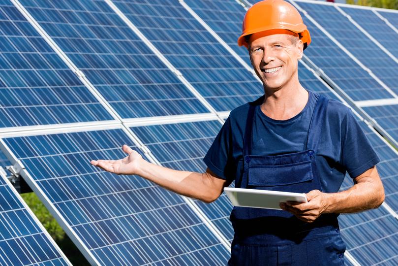 Technician inspecting solar panels on a residential roof in USA