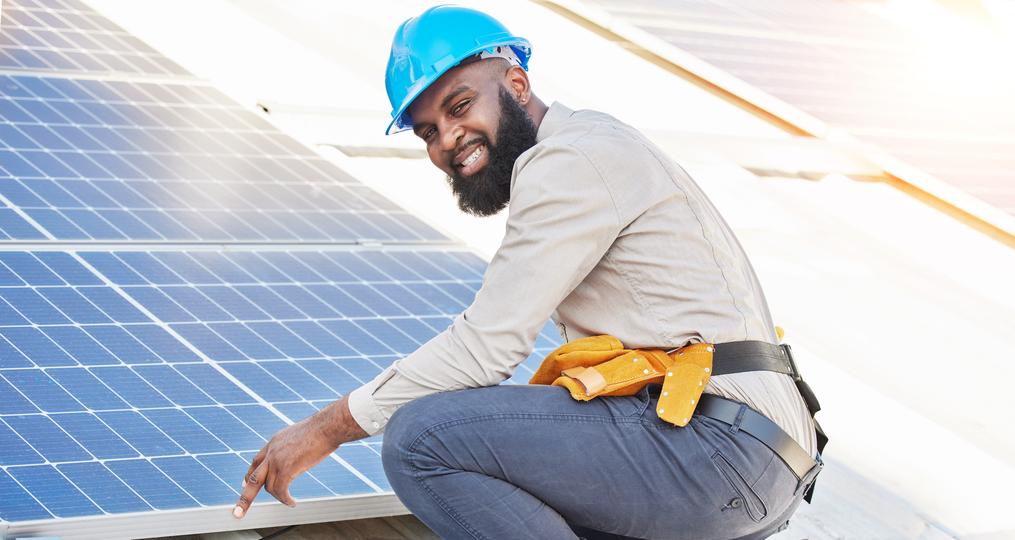 Technician inspecting solar panels on a residential roof in USA