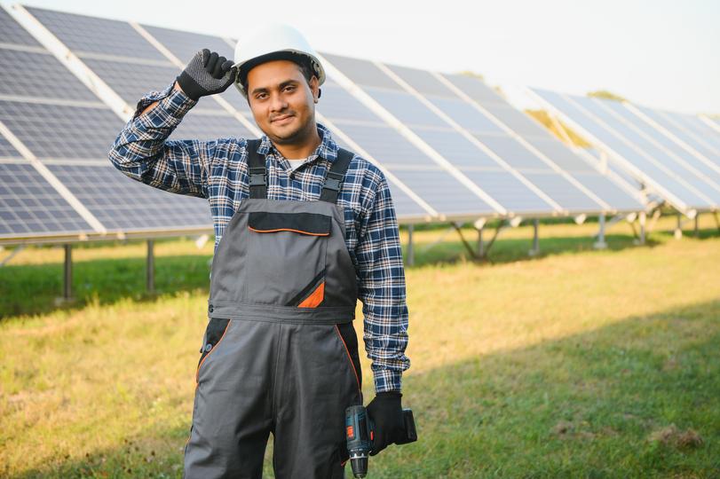 Technician inspecting solar panels on a residential roof in USA